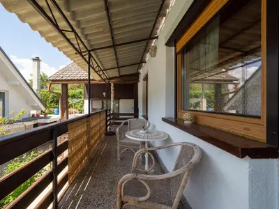 a balcony with two chairs and a table on it at Kiara Apartments & Rooms in Jesenice