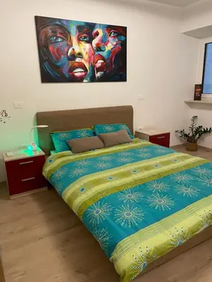 a bedroom with a bed with a painting on the wall at RITUAL in Ajdovščina