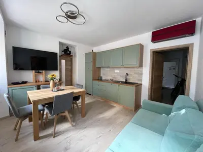 a kitchen and living room with a table and a couch at RITUAL in Ajdovščina