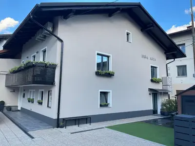 a white house with windows and a balcony at Room Aria in Kobarid