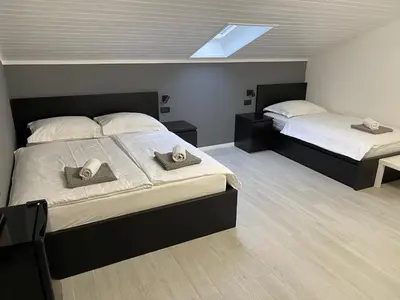 a bedroom with two beds and a skylight at Room Aria in Kobarid