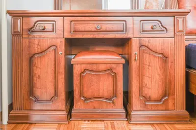 a wooden cabinet with a stool in a room at Holiday House Radovna Bled in Zgornje Gorje