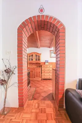 a red brick archway in a room with a kitchen at Holiday House Radovna Bled in Zgornje Gorje