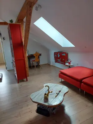 a living room with a red couch and a table at Pr' Šovarjo in Zgornje Gorje