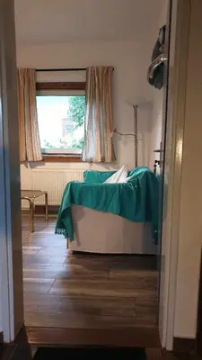 a bedroom with a bed with a green blanket on it at Pr' Šovarjo in Zgornje Gorje