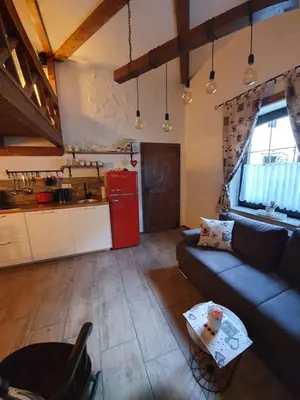 a living room with a blue couch and a red refrigerator at Studio Srce in Kranjska Gora
