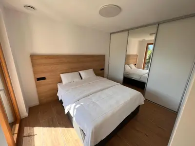a bedroom with a large white bed and a mirror at Vila Petra - Family apartment for 4 at Lake Bled in Bled