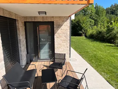 four chairs sitting on a patio next to a house at Vila Petra - Family apartment for 4 at Lake Bled in Bled