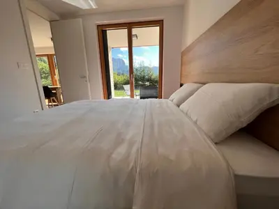 a large white bed in a room with a window at Vila Petra - Family apartment for 4 at Lake Bled in Bled