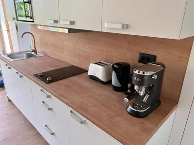 a kitchen counter with a coffee maker and appliances on it at Vila Petra - Family apartment for 4 at Lake Bled in Bled