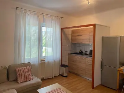a living room with a couch and a kitchen at Apartmaji Iva in Bled