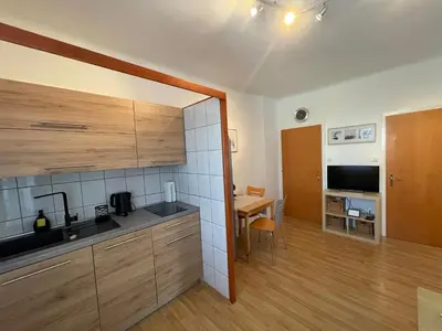 a kitchen with wooden cabinets and a table in a room at Apartmaji Iva in Bled