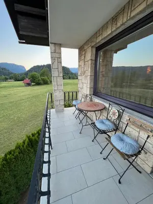a patio with chairs and a table and a window at Apartmaji Iva in Bled