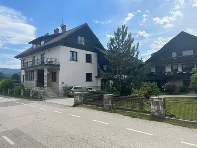 a white house on the side of a road at Apartmaji Iva in Bled