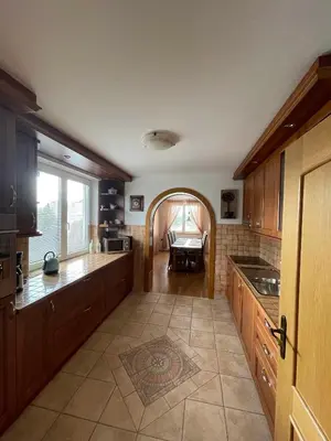 a kitchen with wooden cabinets and a table in it at Apartmaji Iva in Bled