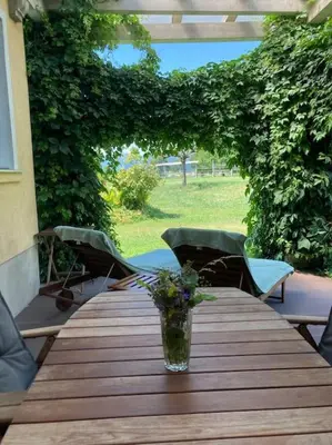 a wooden table with a vase of flowers on it at Vila Mir - Apartment in Begunje na Gorenjskem