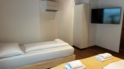 a room with two beds and a flat screen tv at Ars Longa apartments in Ljubljana