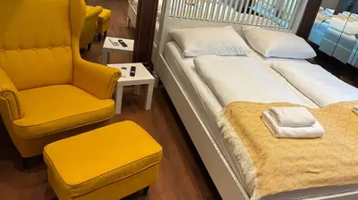 a bedroom with a bed and a chair and a chair at Ars Longa apartments in Ljubljana