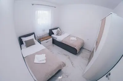 a small bedroom with two beds and a mirror at L Apartment in Maribor