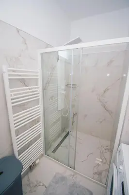 a shower with a glass door in a bathroom at L Apartment in Maribor