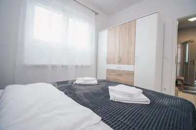 a bedroom with a bed with towels on it at L Apartment in Maribor