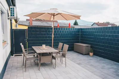 a table and chairs with an umbrella on a patio at L Apartment in Maribor