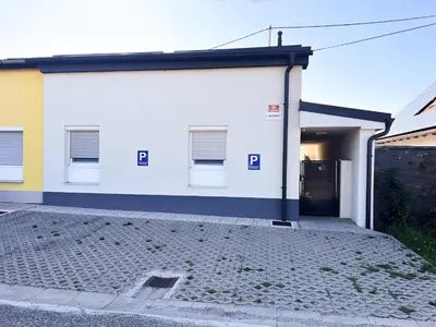 a white building with a door in front of it at L Apartment in Maribor