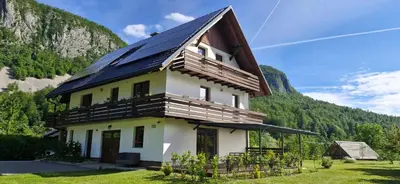 a house with a solar roof on a mountain at Apartmaji ob Savi in Bohinj