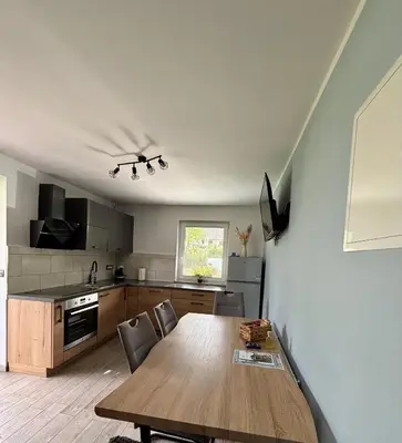 a kitchen with a wooden table and chairs in it at Apartmaji ob Savi in Bohinj