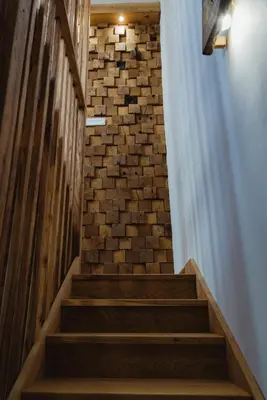 a staircase with a brick wall and wooden steps at Frešer Farm Accommodation in Zgornje Prebukovje
