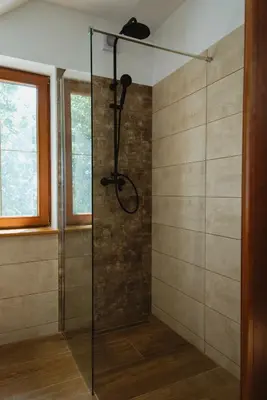 a shower with a glass door in a bathroom at Frešer Farm Accommodation in Zgornje Prebukovje