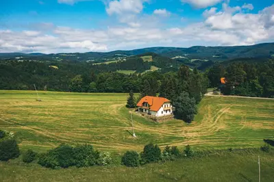 a house in the middle of a green field at Frešer Farm Accommodation in Zgornje Prebukovje