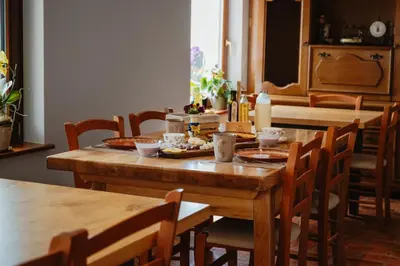 a wooden table with plates of food on it at Frešer Farm Accommodation in Zgornje Prebukovje
