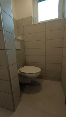 a bathroom with a toilet and a window at Sava river house - apartments in Bled
