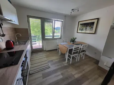 a kitchen and dining room with a table and chairs at Sava river house - apartments in Bled