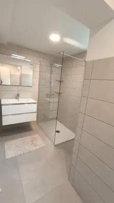 a bathroom with a glass shower and a sink at Sava river house - apartments in Bled