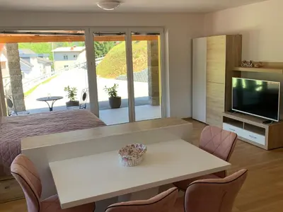 a bedroom with a bed and a table and a television at Apartmaji Prʼ nas in Laško