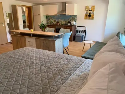 a bedroom with a bed and a kitchen with a counter at Apartmaji Prʼ nas in Laško