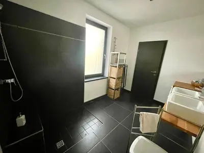 a bathroom with a black wall and a sink at MEGA in Prvačina