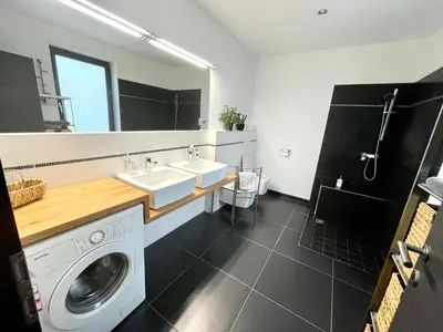 a bathroom with a washing machine and a sink at MEGA in Prvačina