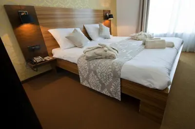 a bedroom with a large bed with white sheets and pillows at Gold Club Hotel & Casino in Ajdovščina