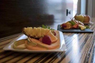 a plate of fruit on a wooden table at Gold Club Hotel & Casino in Ajdovščina