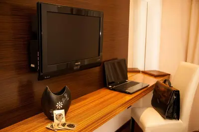 a room with a desk with a television and a laptop at Gold Club Hotel & Casino in Ajdovščina