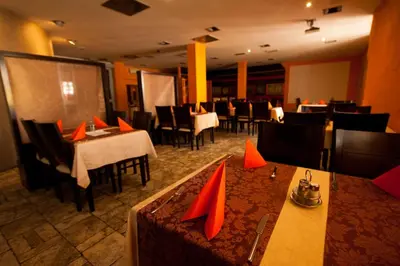 a restaurant with tables and chairs with red napkins on them at Gold Club Hotel & Casino in Ajdovščina