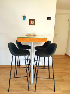 a table with four black bar stools in a room at APARTMA KAPELSKI FANT in Sveti Jurij ob Ščavnici