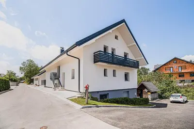 a white building with a balcony on a street at Mojčin Pisker Apartment House in Kranj