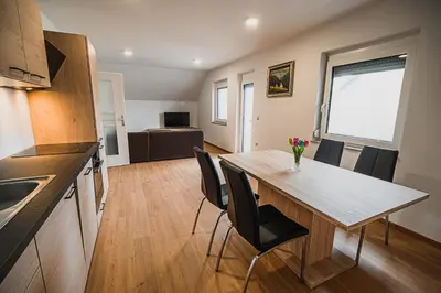 a kitchen and dining room with a table and chairs at Mojčin Pisker Apartment House in Kranj