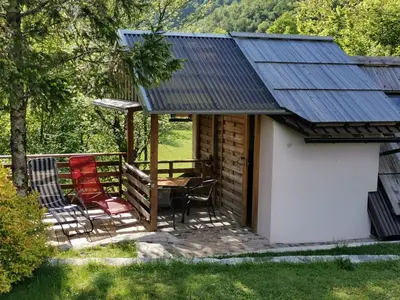 a cabin with a table and chairs on a porch at Glamping Narnia in Bovec