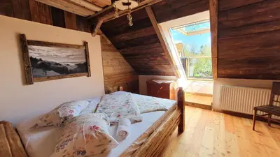 a bedroom with a bed in a room with a window at Chalets Toplak in Sveti Duh na Ostrem Vrhu