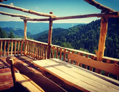a wooden bench sitting on top of a wooden balcony at Chalets Toplak in Sveti Duh na Ostrem Vrhu